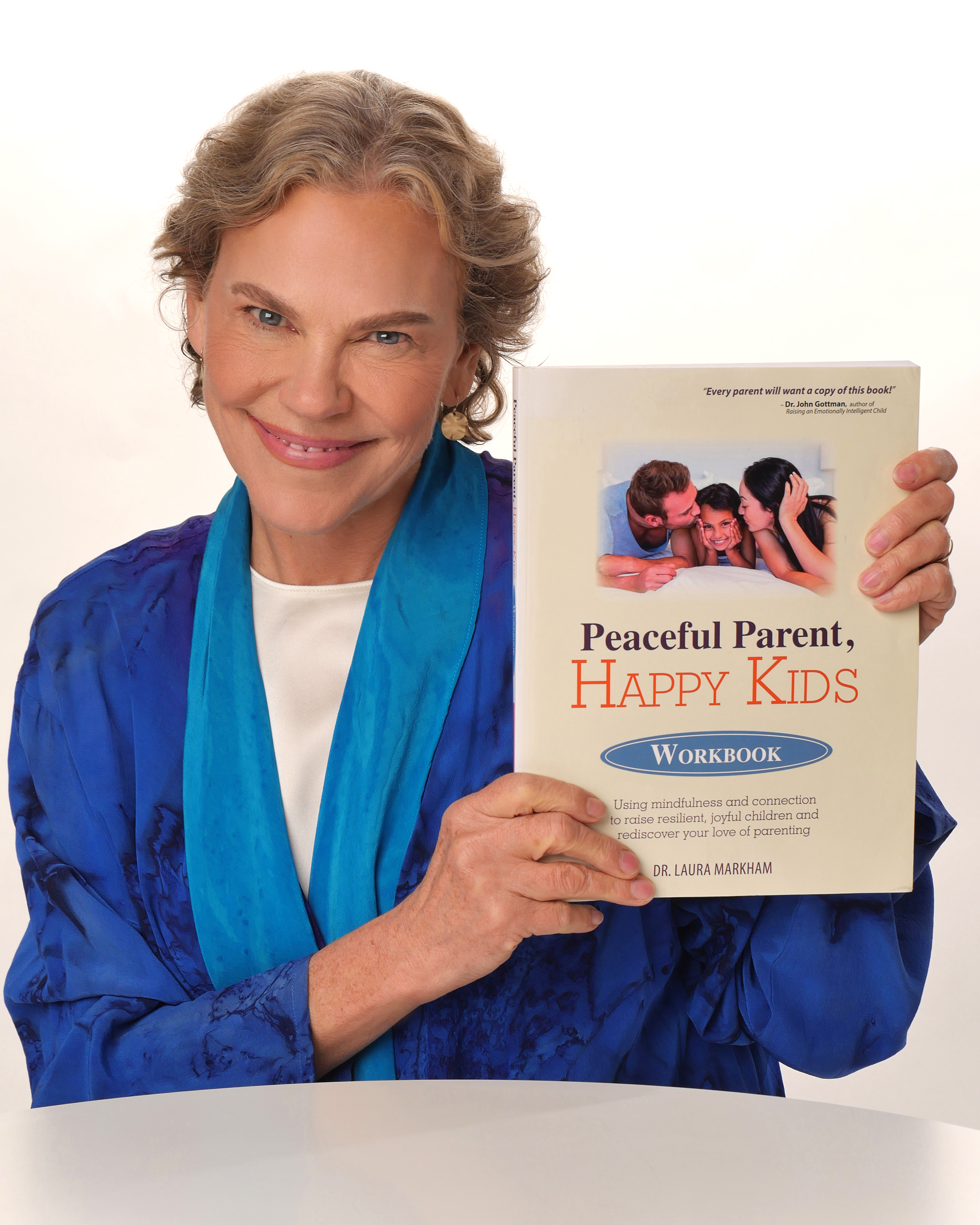Dr. Laura Markham holding the Peaceful Parent, Happy Kids Workbook